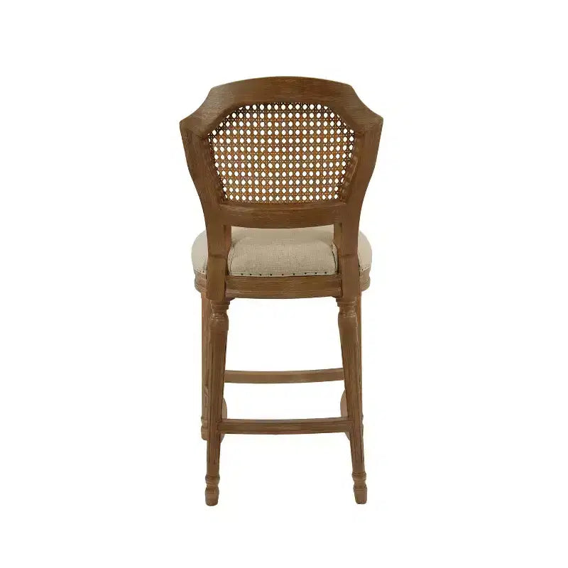 Taburete alto Wilbrandt de roble: tapizado de lino, ribete con clavos decorativos, patas talladas